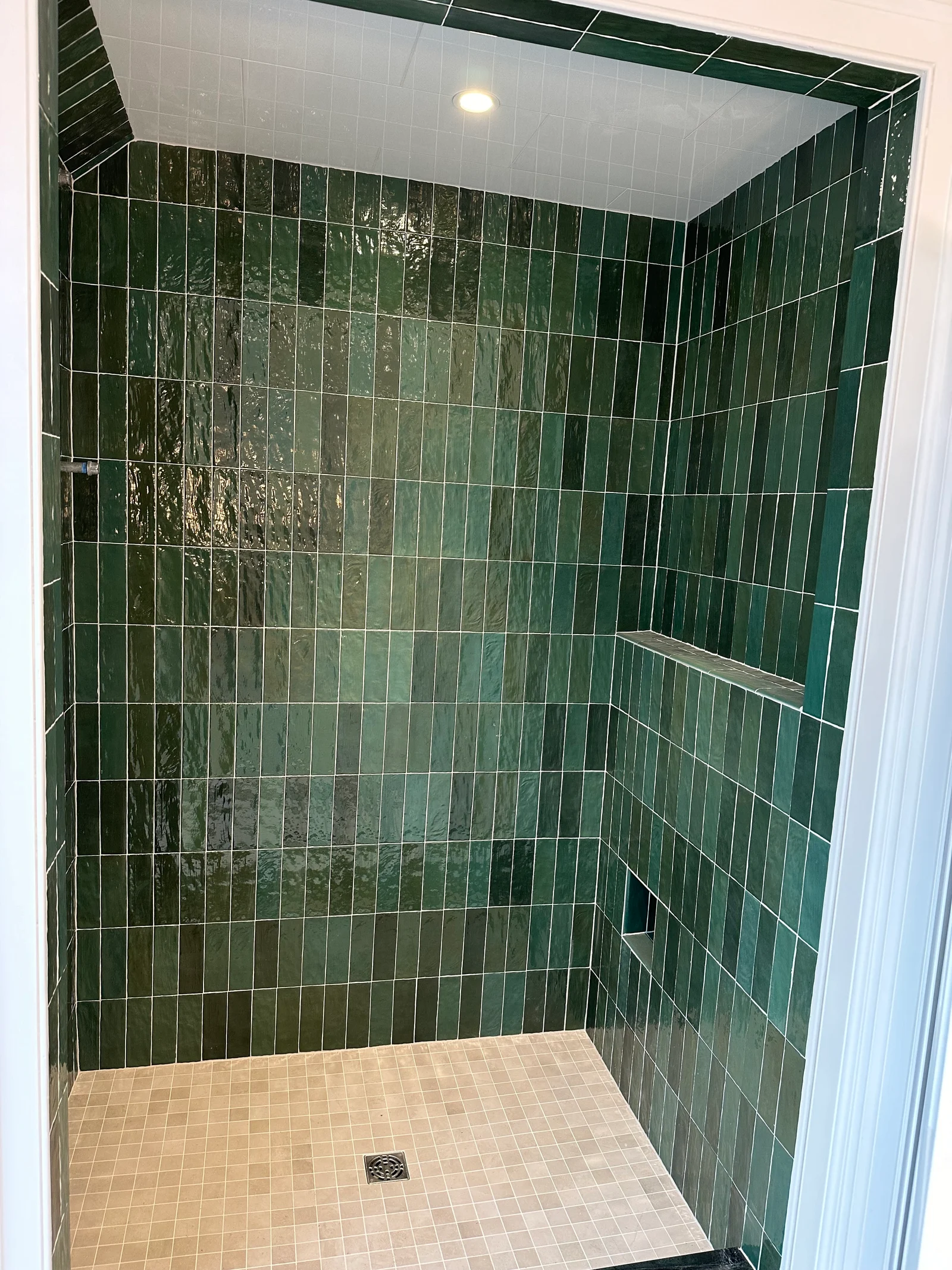Shower with green tile and built-in shelving