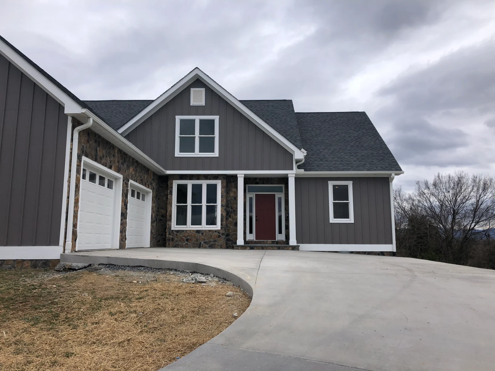 Gray home with stone accents and two garage doors