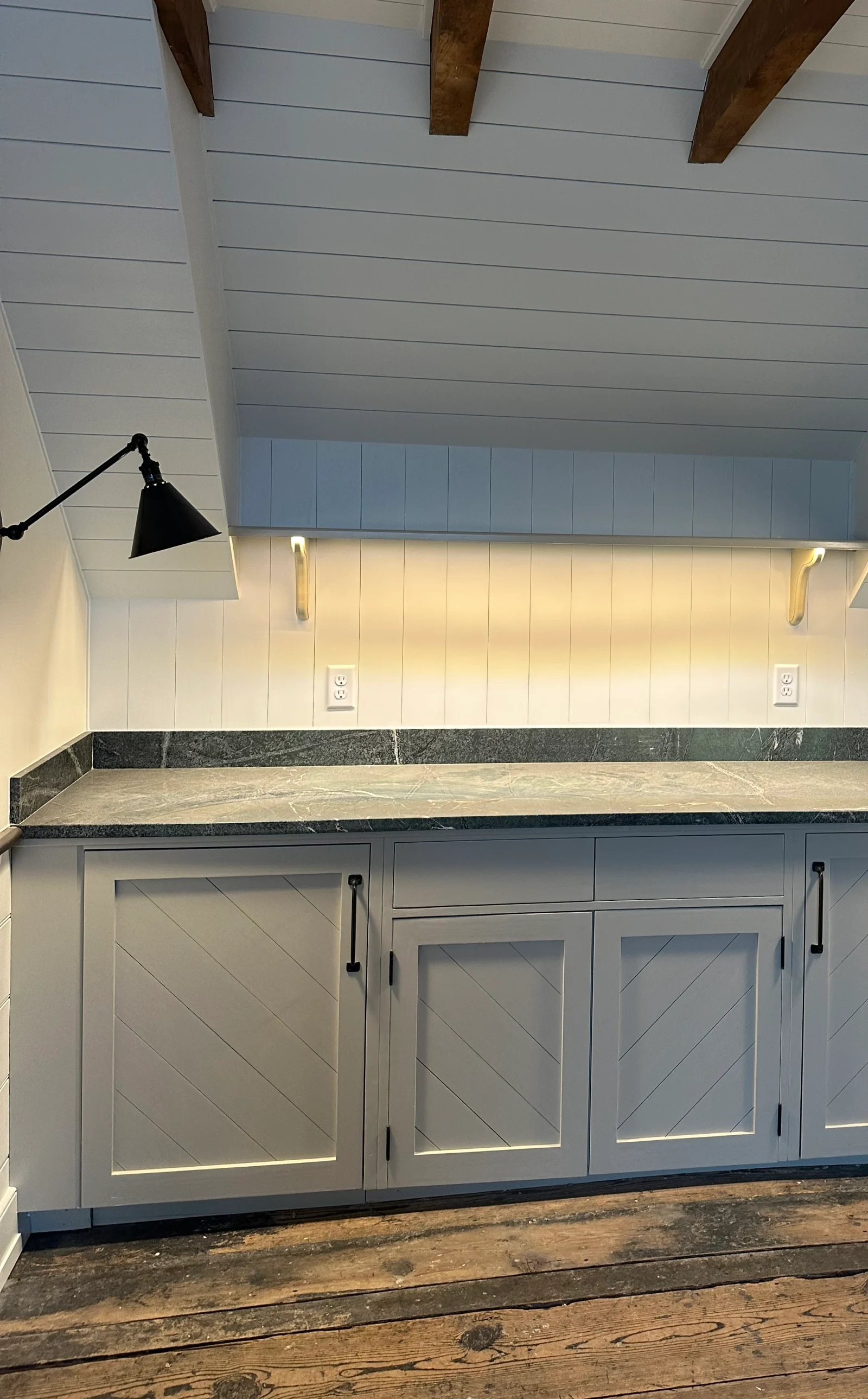 Wood ceiling beams above paneled walls and built-in cabinetry